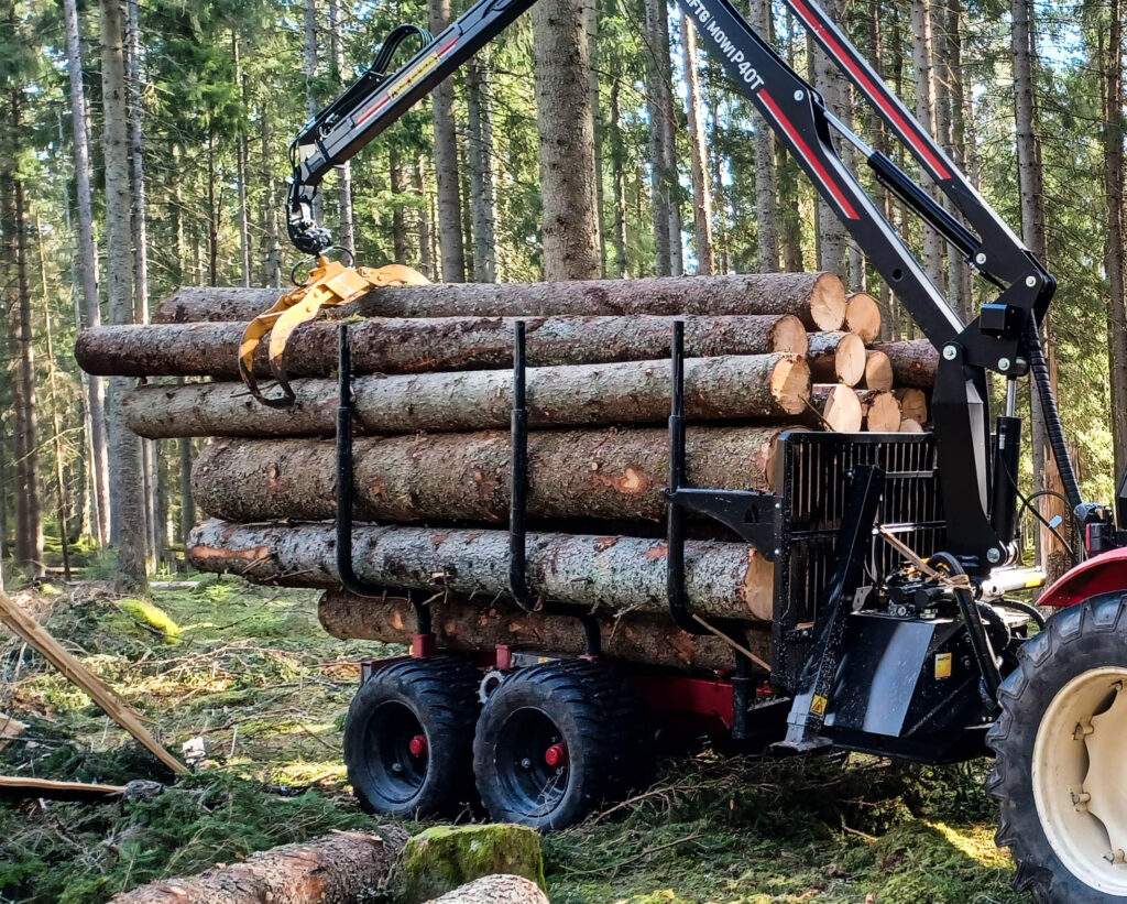 En skogskärra med kran, som är full med stockar.